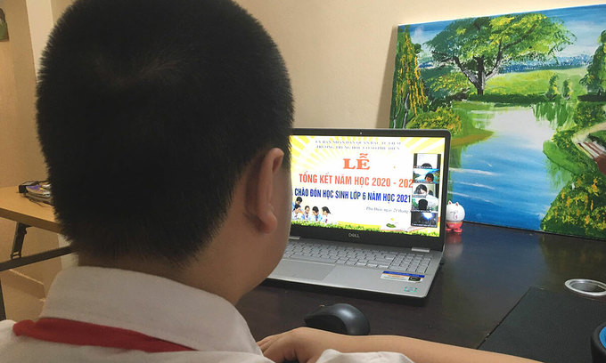 Ученик средней школы Фузьен в районе Бак Ты Лием в Ханое наблюдает за церемонией закрытия учебного года онлайн, 21 августа 2021 года. Фото: VnExpress